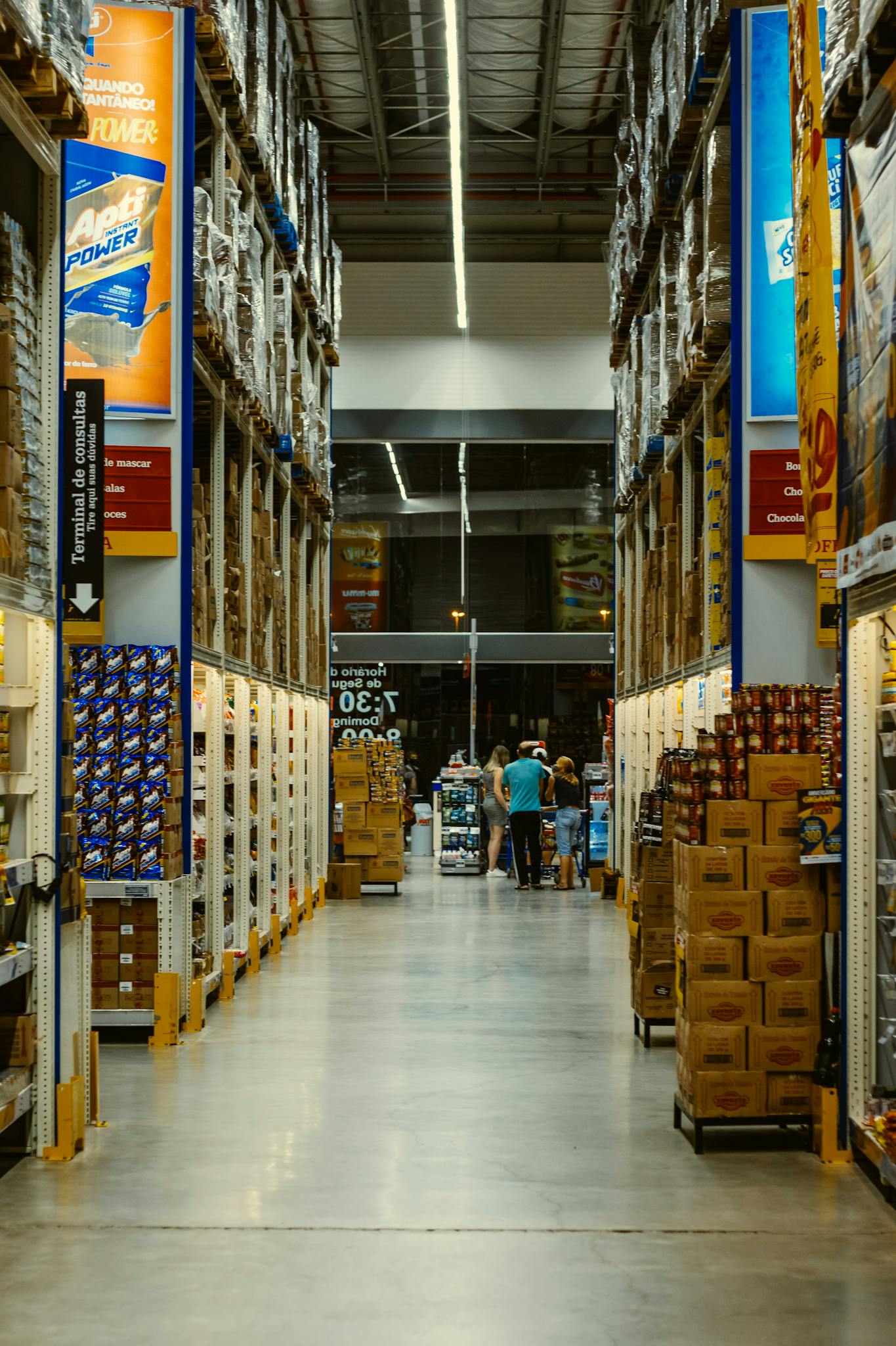 A Vibrant Warehouse Aisle With Shoppers Amidst