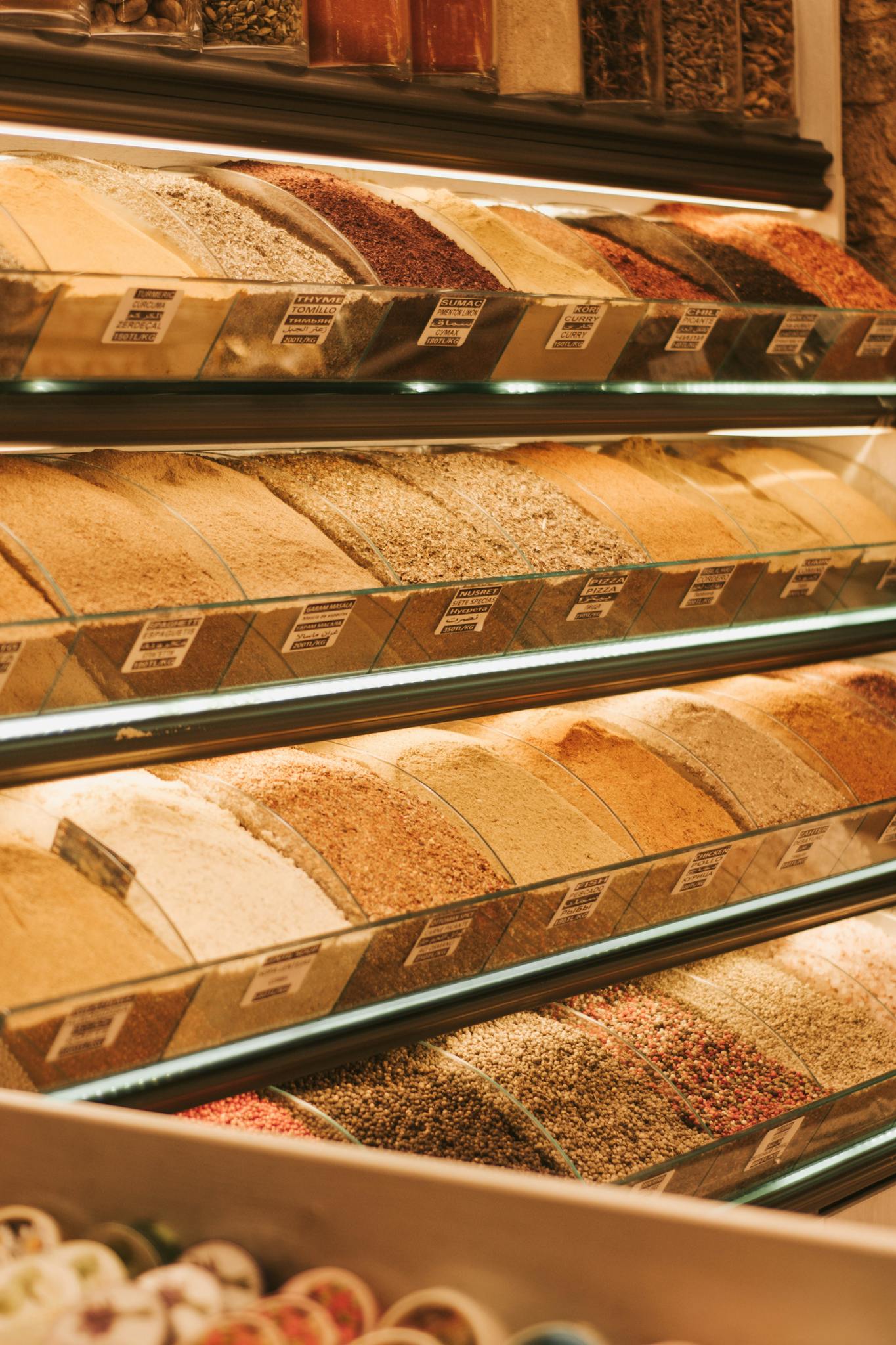 Home An array of grains displayed in an organized manner at a market stall indoors.