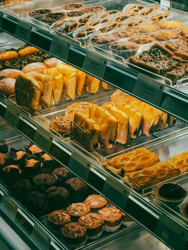 Home A vibrant display of assorted fresh baked goods in a bakery showcase.